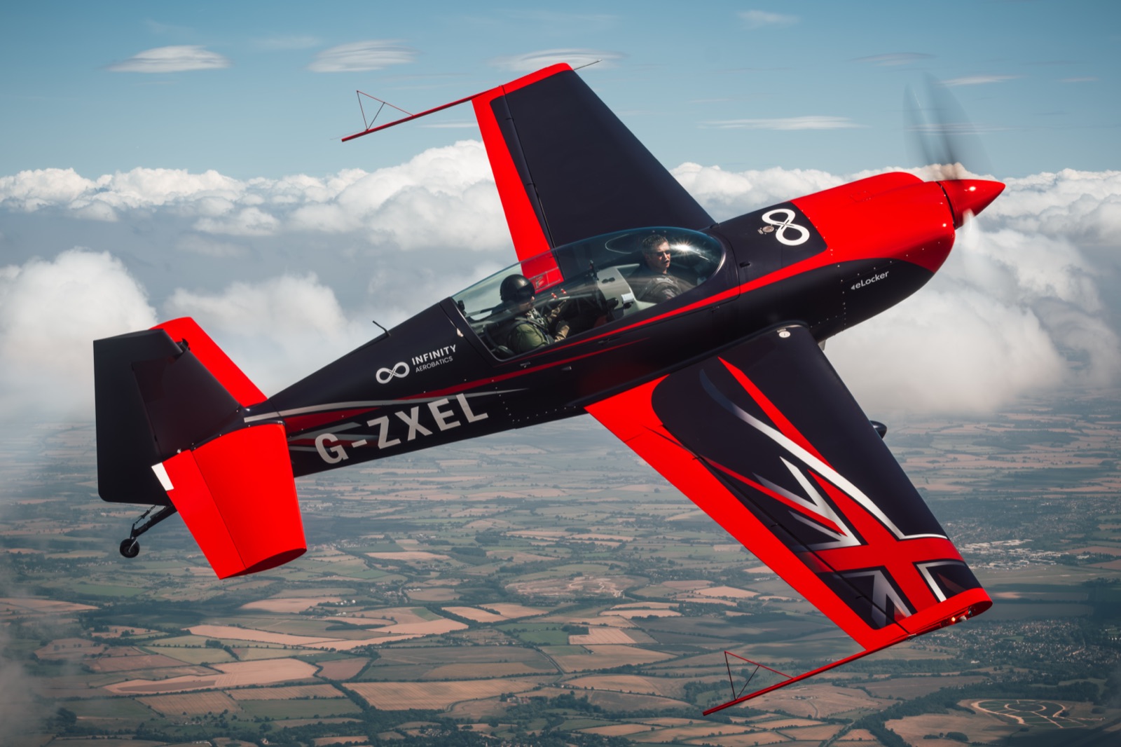 The Extra 300 above the clouds with the Union Jack tail catching the light
