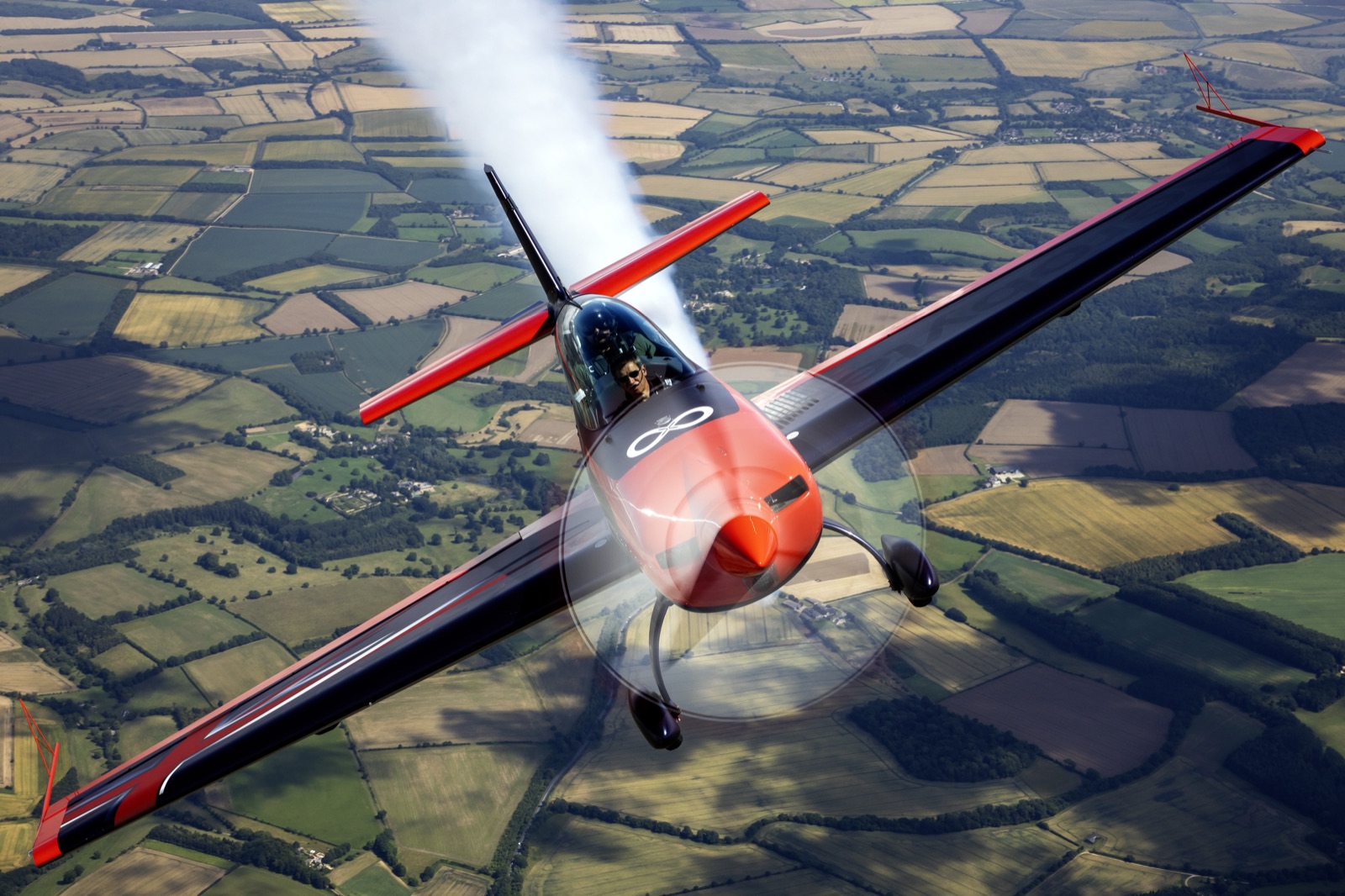 The Extra 300 pulling into a climb with smoke on