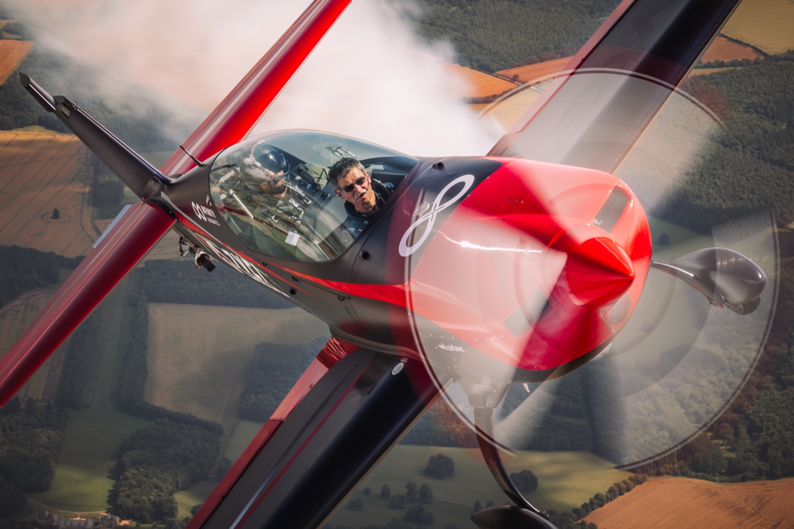Close-up of the Extra 300 turning hard, pilot visible in the cockpit