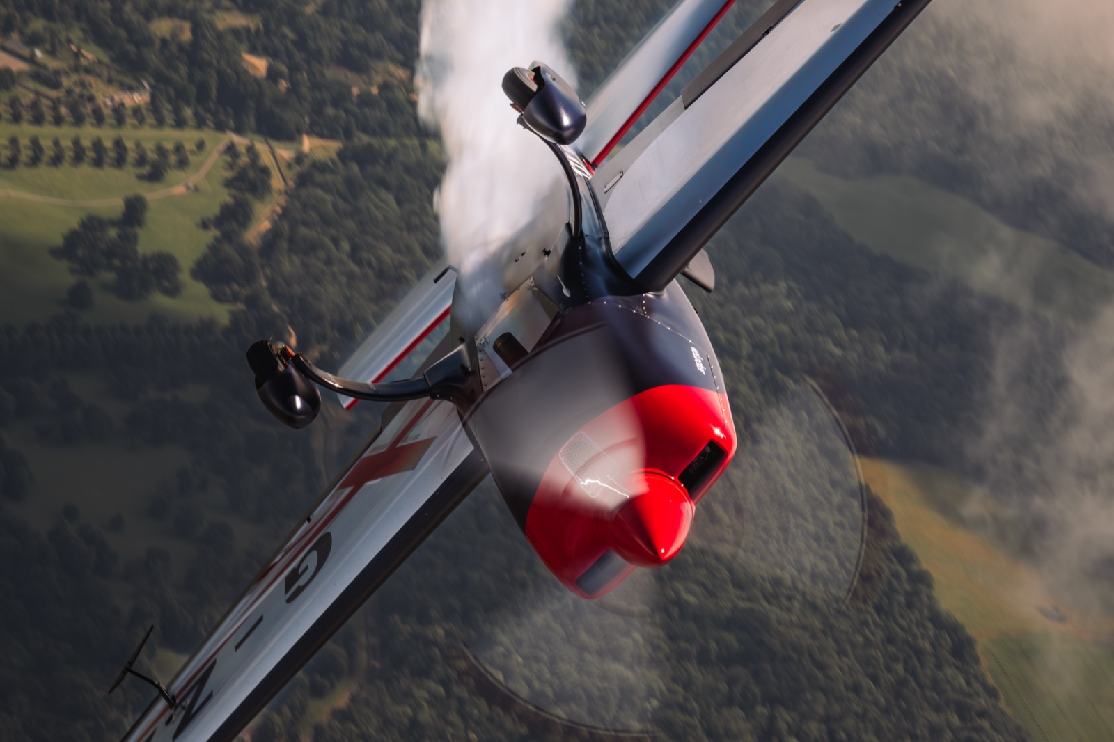 The Extra 300 diving away through the cloud tops