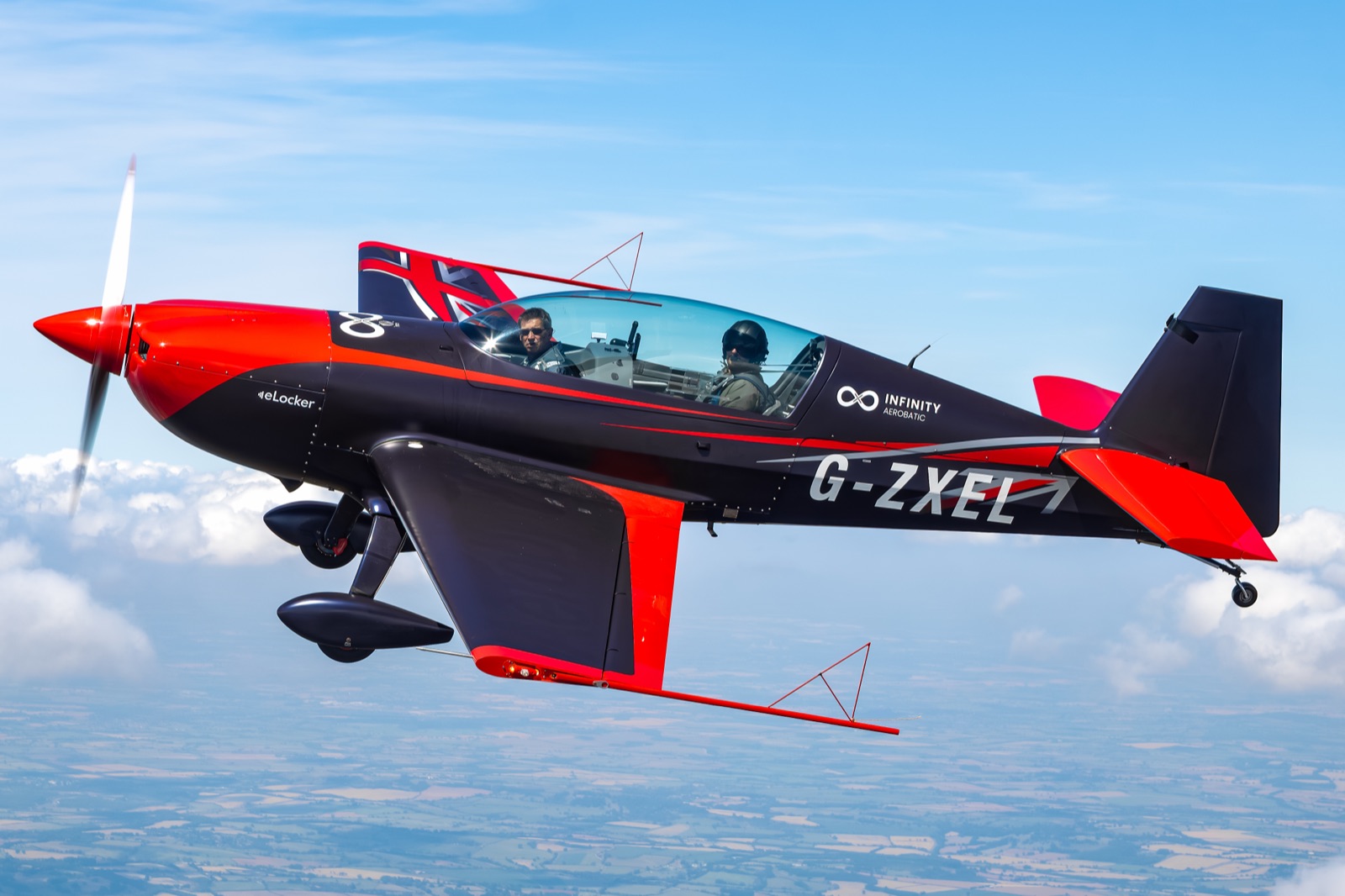 Side view of the Extra 300 in flight against a blue sky