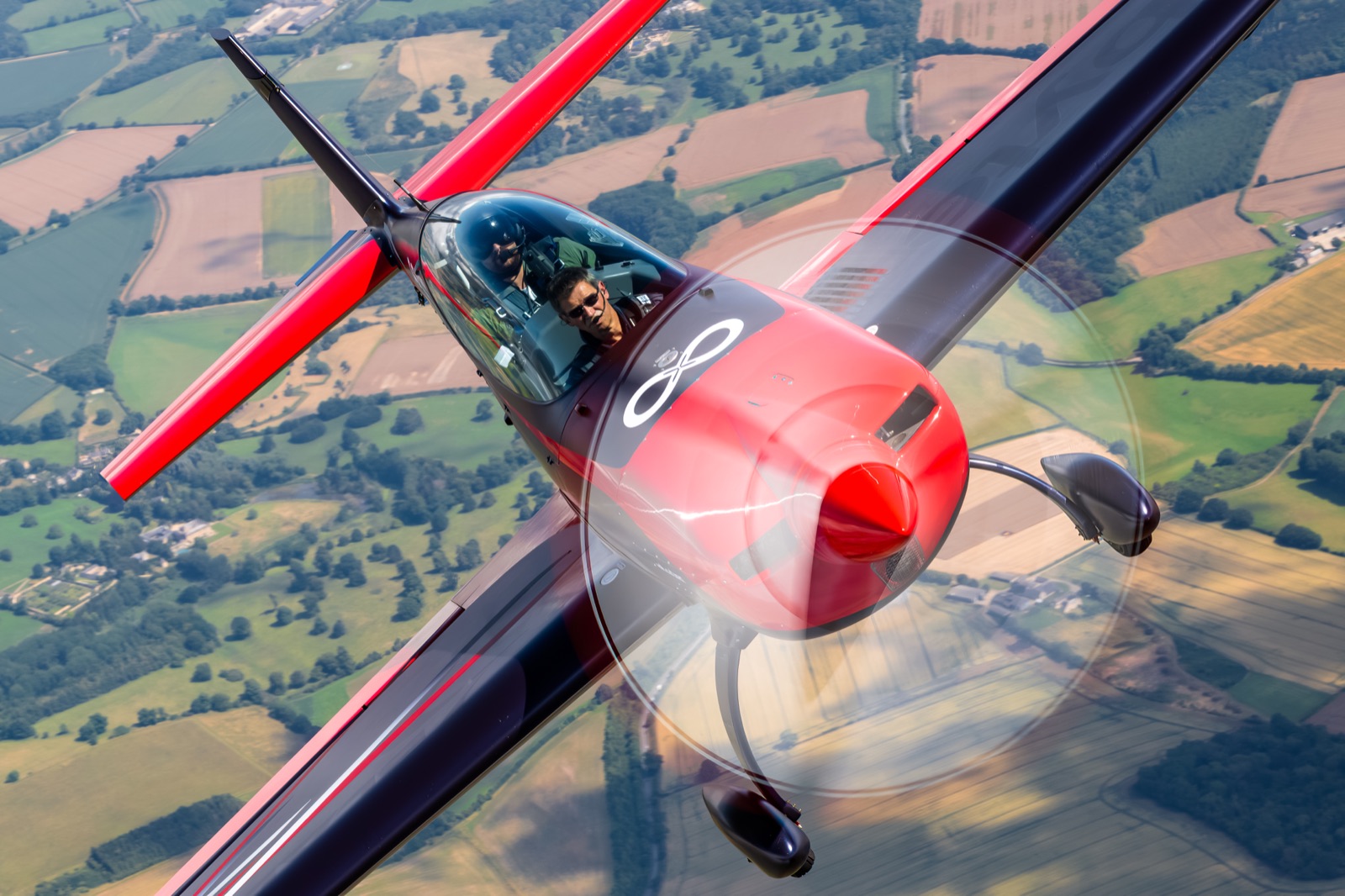 The Extra 300 in level flight against a clear blue sky