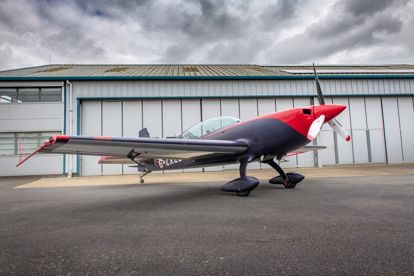 The Extra 300 (G-ZXEL) outside the hangar under a moody sky