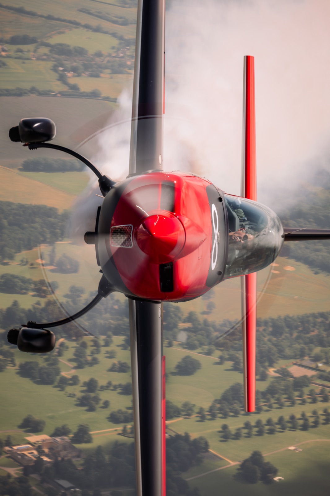 The Extra 300 pointing straight up with smoke on