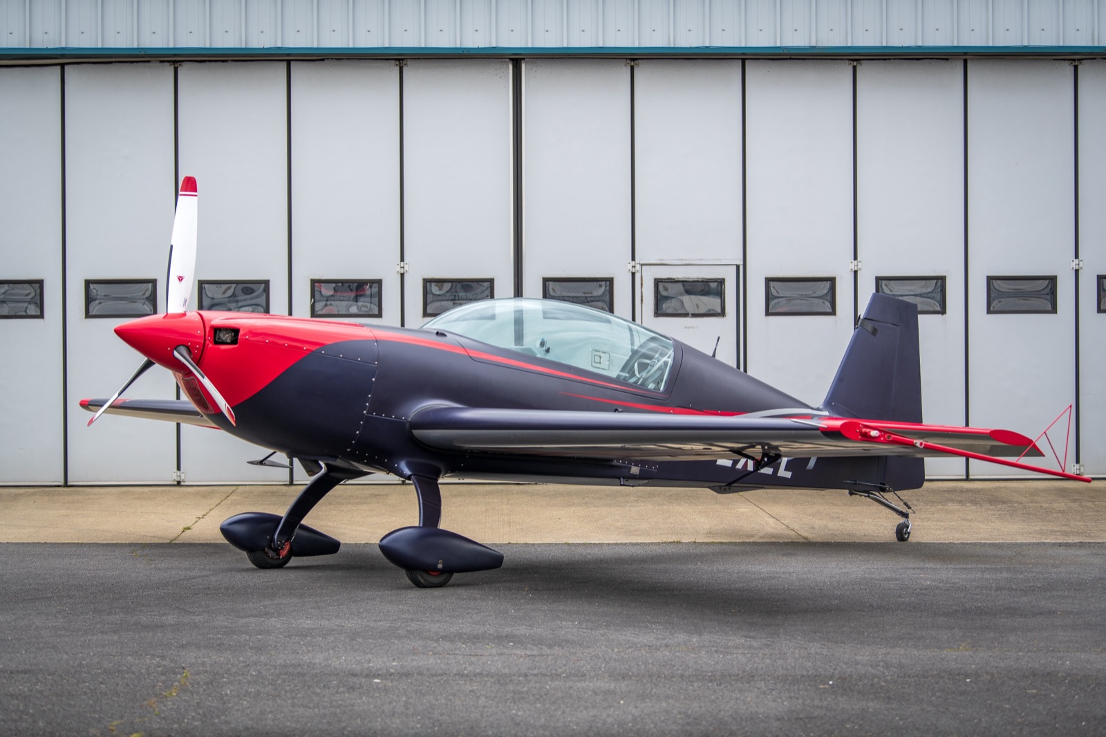 The Infinity Aerobatics Extra 300 (G-ZXEL) side-on outside the hangar